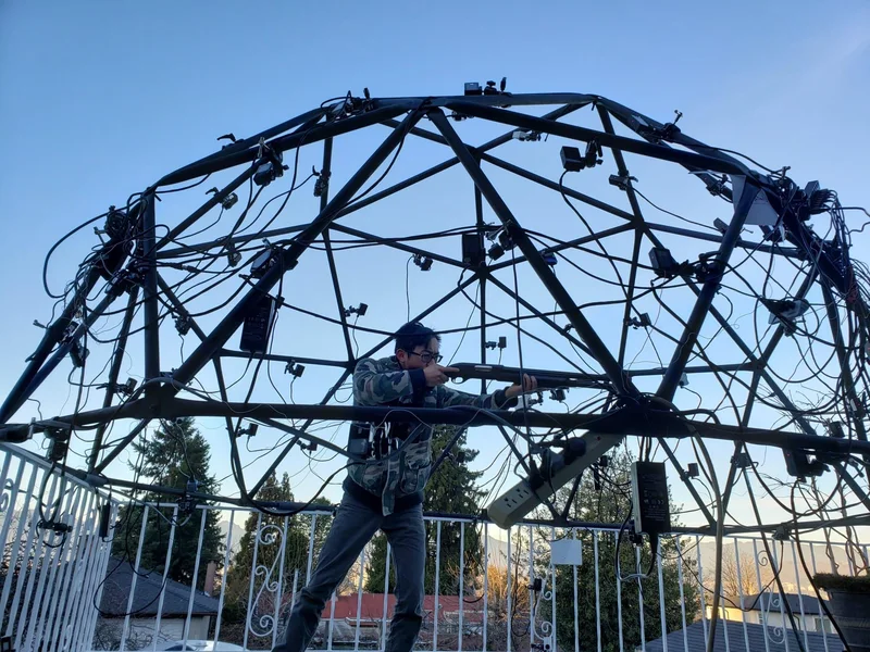 Outdoor capture dome under a blue sky, with a performer inside.