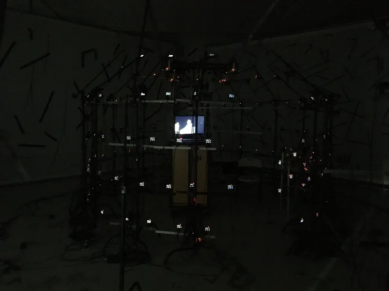 Low-light stage with monitoring screens; darker alternate angle.