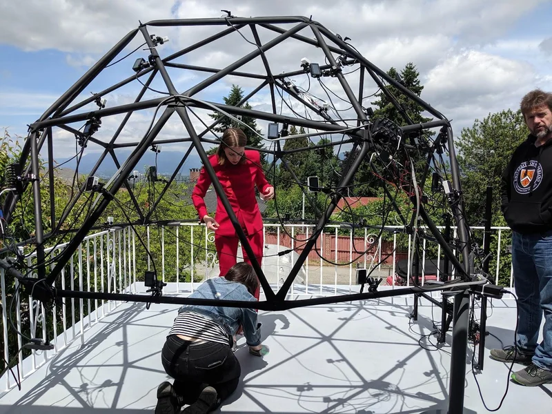 Outdoor volumetric capture dome with a performer in red.