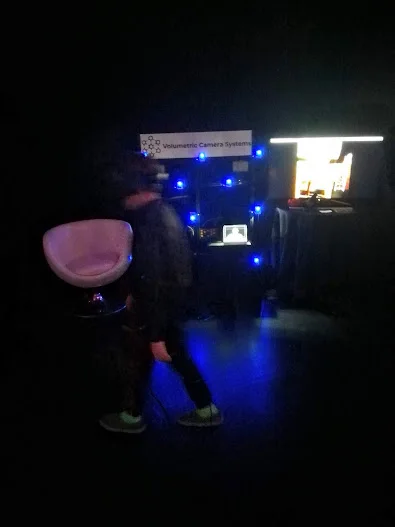 Portrait view of an attendee at the illuminated VCS array in the dark VIFF demo room.