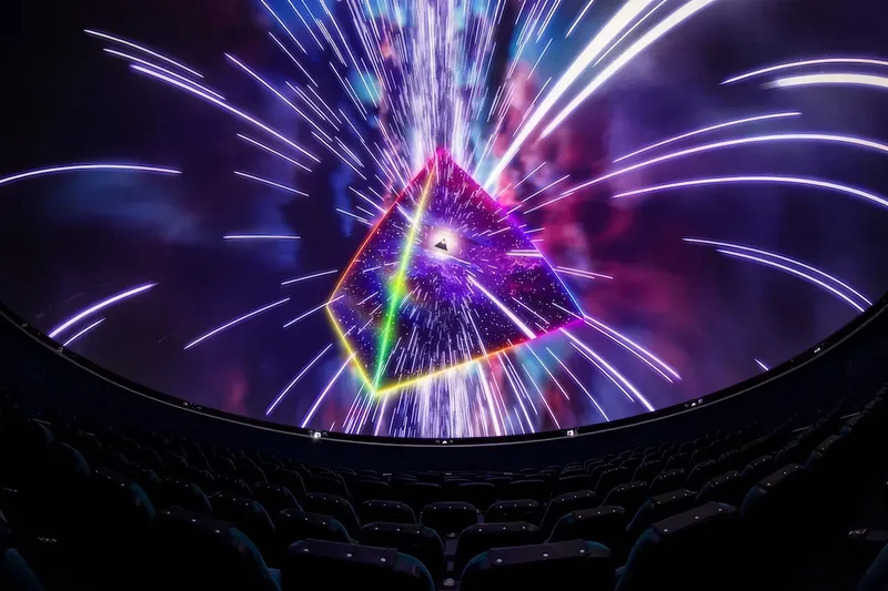 Wide Dome theatre photograph with illuminated triangular Pink Floyd projection and seats.