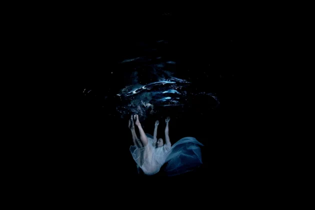 Metamorphosis underwater film still with a suspended figure.