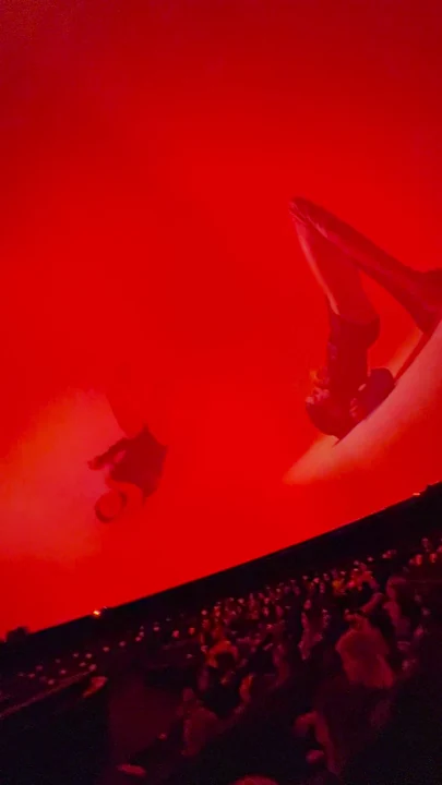 Metamorphosis across the dome screen with the audience in the theatre. Frame from a live-performance recording.