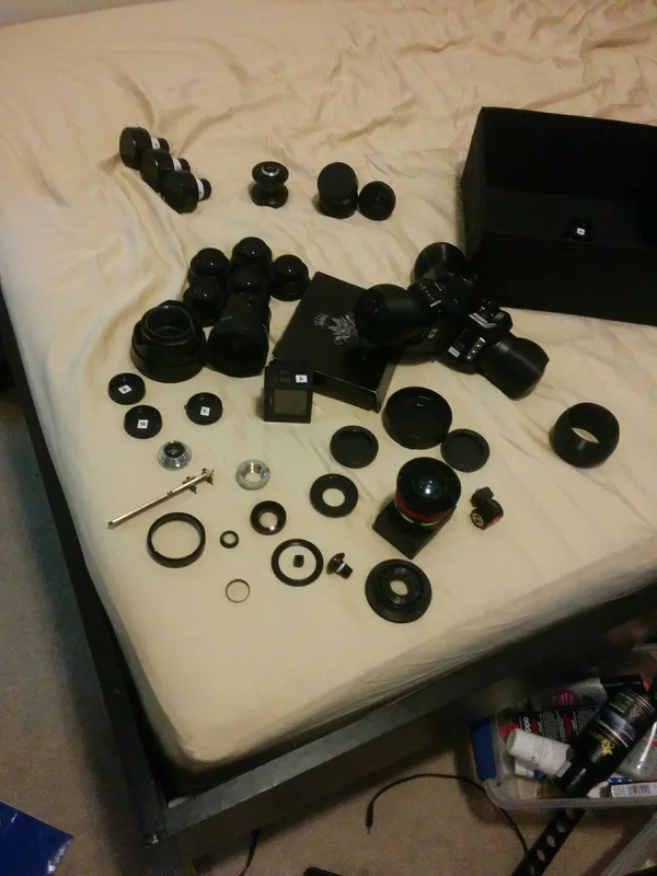Disassembled lens components and housings on workbench.
