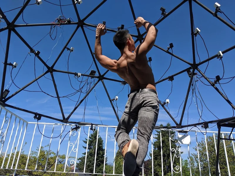 Low-angle outdoor dome capture with performer under blue sky.