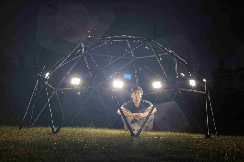 Nighttime outdoor dome array with performer and lights.