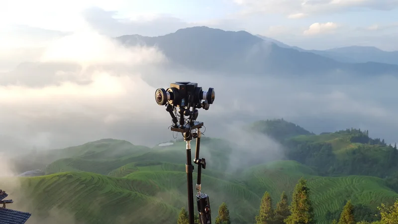 Custom panoramic camera prototype overlooking misty terraced mountains.