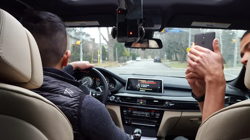 Back-to-back fisheye camera mounted inside a car; occupants visible.