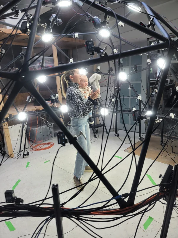 Close portrait of lit multi-camera rig and capture-space wiring.