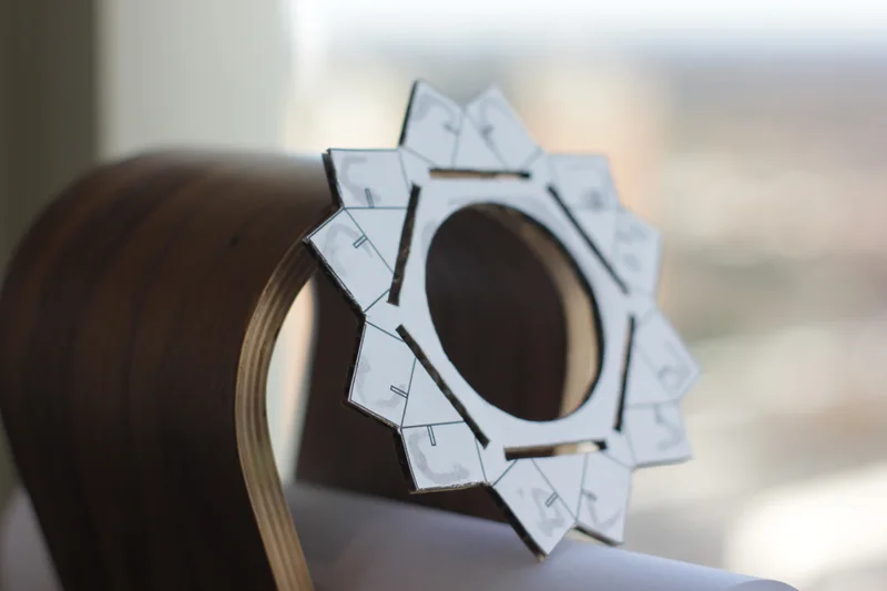 Cardboard/white tracing pattern prototype illustrating angular lens geometry.